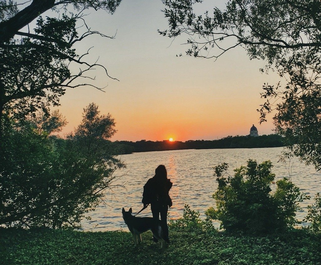 Grace with Akela by the water at sunset